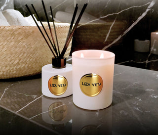 White reed diffuser and natural candle are placed in the bathroom.