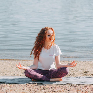 A woman is relaxing on the beach and meditating.