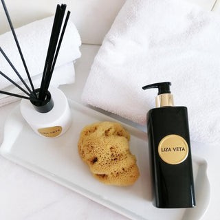 Aromatherapy reed diffuser, body sponge and lavender body wash are on the bathroom table