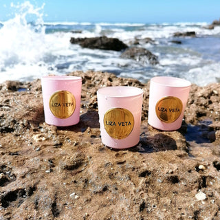 Natural candles with essential oils in pink glass.